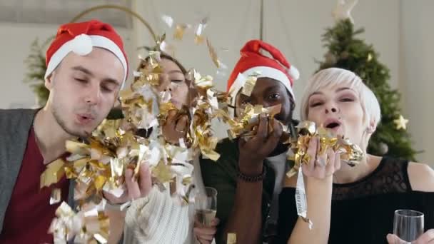 Detail. Čtyři veselé Smíšené rasy lidí vane zlaté konfety z rukou na vánoční oslavu nebo na nový rok. Pojetí večírku