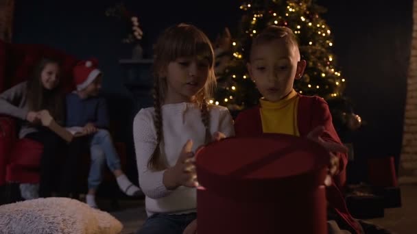 Portret strzał Happy kids otwarcie prezent podczas świąt Bożego Narodzenia i zobaczył specjalną niespodziankę. — Wideo stockowe