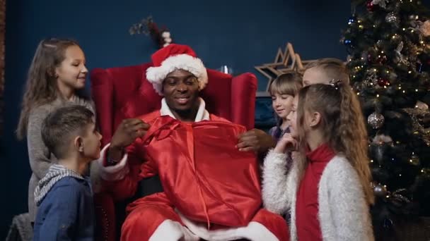 Portraitaufnahme eines lächelnden Weihnachtsmannes, der Geschenke für Kinder verteilt. — Stockvideo