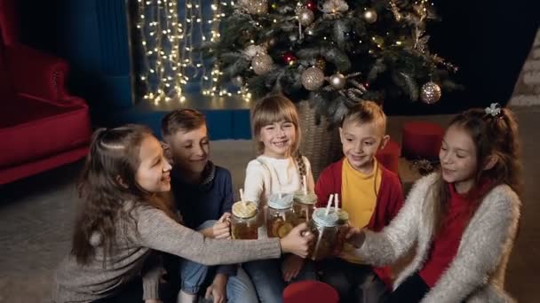 Glückliche stilvolle Kinder jubeln Tasse und trinken Tee in der Weihnachtszeit. — Stockvideo