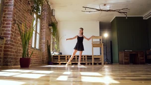 Jovem bailarina encantadora em terno preto praticando em pirueta no estúdio de dança. Linda menina magro dançando balé clássico no ginásio moderno ou salão de baile — Vídeo de Stock