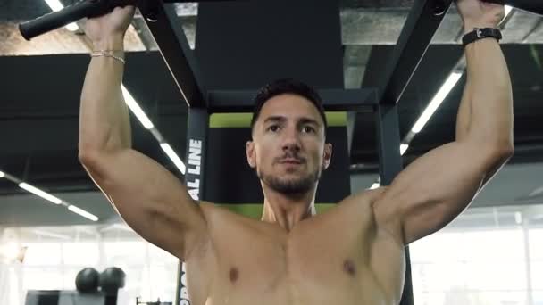 Portrait de l'homme confiant faisant des pull-ups dans la salle de gym . — Video