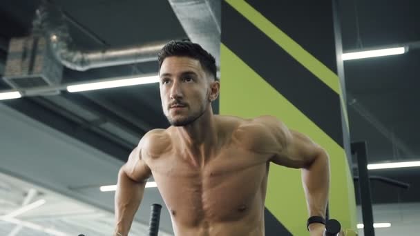 Fuerte joven haciendo pull-ups en las barras paralelas en el gimnasio . — Vídeos de Stock