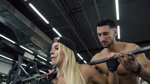 Mujer deportiva concentrada sentada con barabells durante el entrenamiento personal en el gimnasio . — Vídeos de Stock