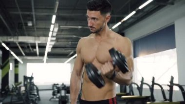 Yakışıklı erkek t-shirt verme egzersizleri eller için olmadan dumbbells ile uygun..