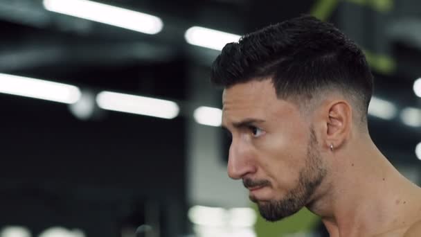 Duro workng hombre haciendo conjuntos con barras durante el entrenamiento en el gimnasio . — Vídeo de stock