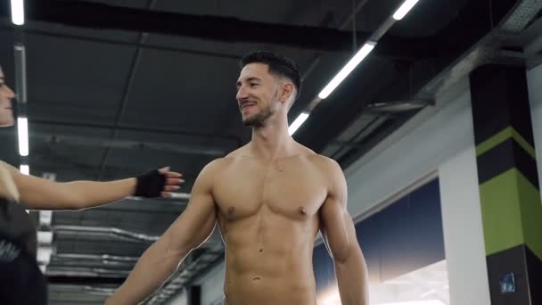 Hombre atractivo sin camiseta y mujer sexy caminando en el gimnasio . — Vídeo de stock