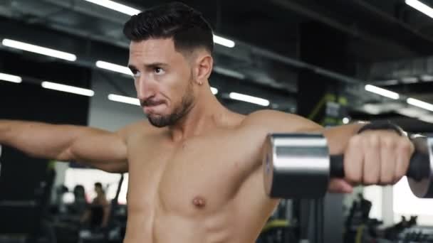 Portrait d'un gars qui travaille dur avec un torse de serpent faisant des exercices pour les mains avec des haltères . — Video