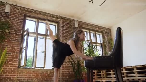 Carina ragazza pratica ginnastica nella moderna scuola di sport, si allunga, si divide in piedi su una gamba, mentre appoggia la mano sulla sedia. Scuola di danza classica, danza professionale, ballerina — Video Stock