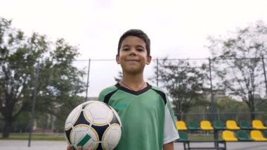 Kameraya bakarak futbol topu ile boy gülümseyerek.