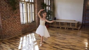 Beyaz elbise ve Bale ayakkabıları genç Balerin Bale unsurları gerçekleştirir. Çekici dansçı klasik bale dans unsurları gerçekleştirir
