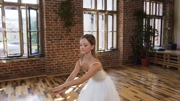 Elegante bailarina encantadora en tutú blanco realizar danza clásica en la escuela de ballet. Joven bailarina delgada en vestido blanco realiza danza de ballet en el estudio — Vídeo de stock