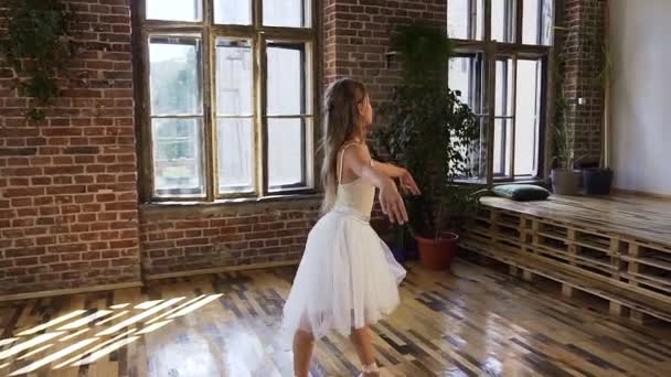 Dançarina de balé vestida em tutu branco executar dança balé clássico, ela treina graciosamente em sapatos de balé pointe na escola de bola. Graciosa bailarina encantadora praticando movimentos de balé no salão de dança — Vídeo de Stock