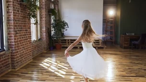 Adolescente graziosa ragazza in abito bianco tutù pratica balletto nella moderna scuola di balletto. Graziosa ballerina sensuale in abito bianco elementi di danza classica o moderna — Video Stock