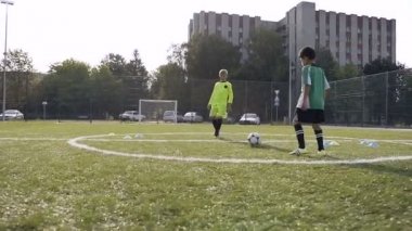 İki erkek futbol eğitimi sırasında futbol topu tekmeleme.