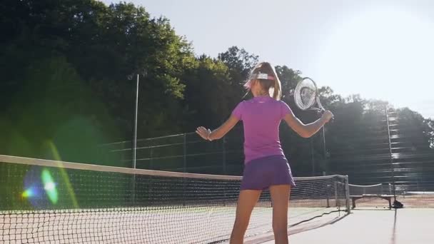 Attraktiva flicka praxis i att slå med en racket under träning. — Stockvideo