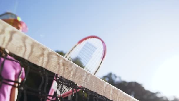 Jugadoras de tenis estrechando las manos sobre la red de canchas de tenis . — Vídeo de stock