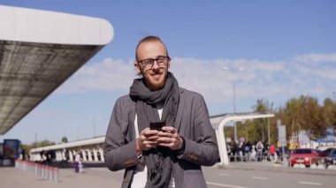 Beyaz genç adam mesaj sms City akıllı telefon app kullanma. Yakışıklı genç işadamı smartphone kullanır. Açık havada. Kentsel erkek profesyonel onun 20 dakika içinde commuting-25 yaşında