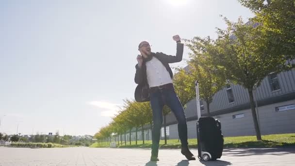 Beau homme d'affaires fait des mouvements drôles tout en se tenant à l'extérieur près de l'immeuble de bureaux. Homme cadre de la publicité avec valise danse dans la rue. À l'extérieur — Video