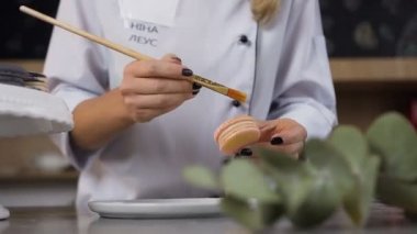 Altın sıçrama ile dekorasyon macaroons eller kadın. Önlük üzerinde yazıt, model adı Nina Leus