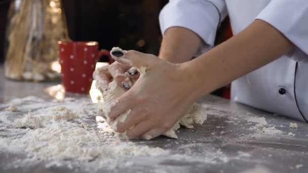 Widok z boku z młodych cukiernik wyrabiania ciasta z mąki na stole. — Wideo stockowe