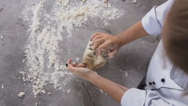 Młody cukiernik wyrabiania ciasta z mąki na stole. — Wideo stockowe