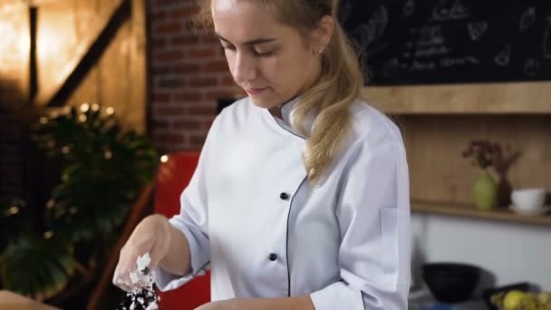 Dolly tiro de confitero joven haciendo malvavisco en la cocina, arrojando azúcar en polvo . — Vídeos de Stock