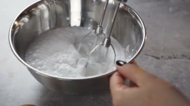 Beyaz yumurta krema motor Mikser kullanarak kase karıştırma kadın el atış yukarıya kapatmak.