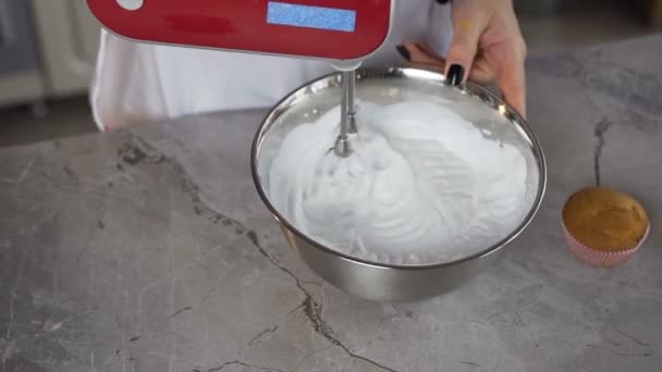 Kobiece baker za pomocą silnika mikser do mieszania białe jajko krem w misce. — Wideo stockowe