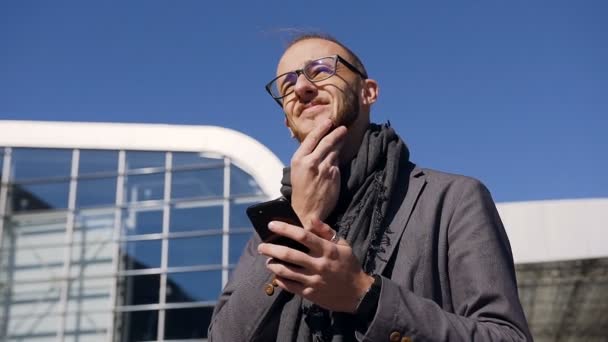 Közeli kép: a sikeres üzletember, aki használja a smartphone, miközben ő séta során működő ebédszünet. Fogalmának technológia, telefonos, üzleti utak, üzleti, wall street — Stock videók