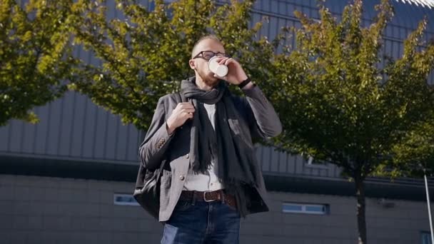Fiatal kaukázusi üzletember modern belvárosi kávét iszik. A szabadban. Fiatal szakállas üzletember járkálni épület kávé italok alatt ebédszünet — Stock videók