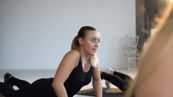 Side view of young fitness instructor with fitness group people who perform yoga lesson, stretching exercises. Concept of sport, yoga, fitness, step aerobics, and healthy lifestyle — Stok video