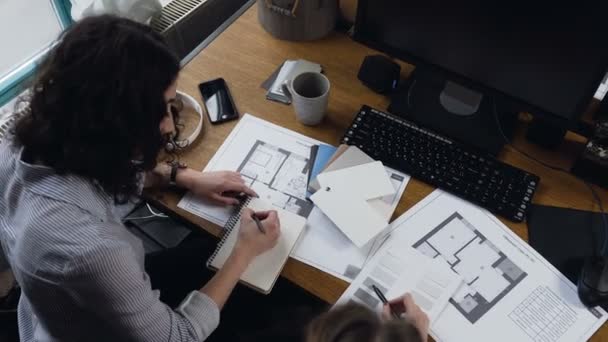 Dos arquitecta trabajando en el proyecto de motores en el fondo de la oficina . — Vídeos de Stock