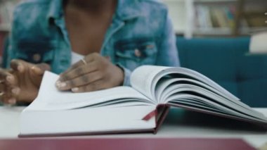 Kitap sayfaları çevirme Afrikalı kadın el atış kapatın.