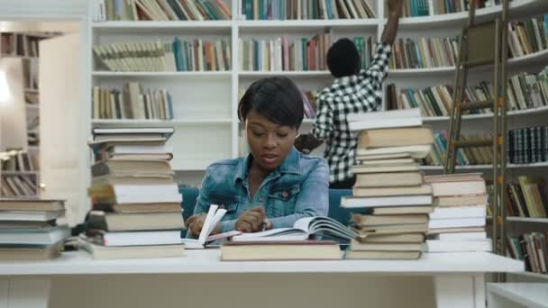 図書館で本を読んでのアフリカの女性を集中してください。. — ストック動画