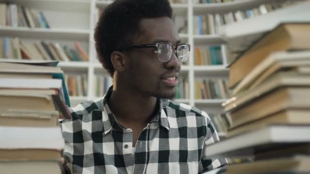 Afrikanischer junger Mann in der Bibliothek. — Stockvideo