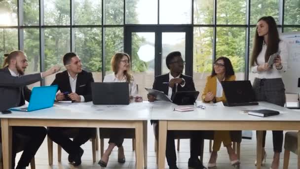 Uma equipe de negócios confiante e atrativa do grupo multiethnical dos povos está prendendo uma reunião de negócio em um escritório claro, moderno. — Vídeo de Stock