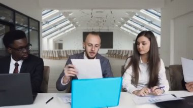 Çok etnik başarılı iş adamları office masada oturan grup toplantısında, 4 k dizüstü bilgisayarda çalışan Şirket belgeleri, raporlama doğrulanmadı