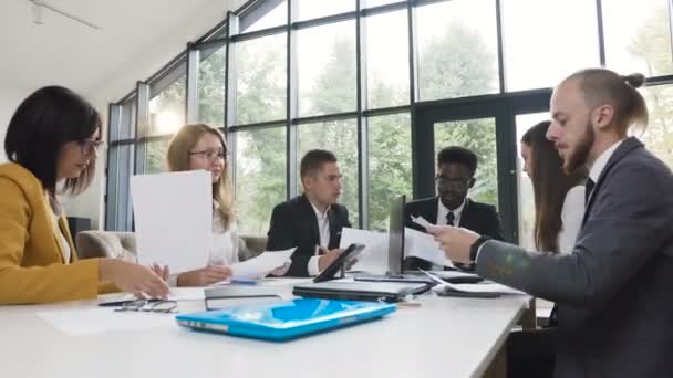 Groep van jonge multi etnische zakenmensen voldoen aan bestuurskamer tafel bespreken financieel verslag met behulp van grafieken en winst verslagen op winsten kosten bedrijf — Stockvideo