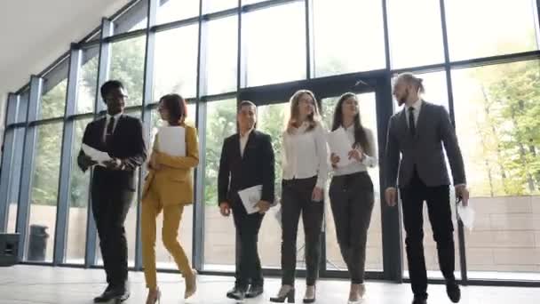 Ritratto di un gruppo di giovani uomini d'affari multietnici che vanno in conferenza presso l'ufficio moderno. colleghi d'affari di successo presso la spaziosa sala moderna con grande finestra che si affaccia sul parco — Video Stock