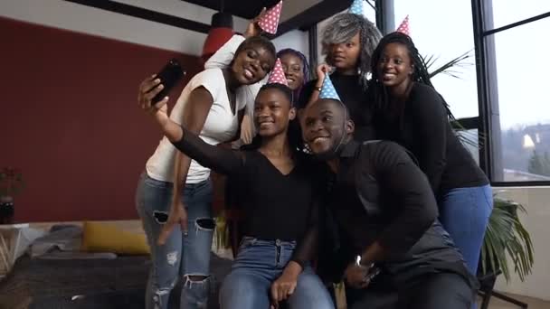 Dolly shot of happy friends using smart phone making selfie pendant la fête d'anniversaire . — Video