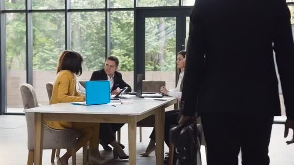 Empresario afroamericano vestido de traje formal con maletín entrando en la oficina de la sala de reuniones dando la mano a sus colegas. Hora de la reunión. Dolly disparó — Vídeos de Stock