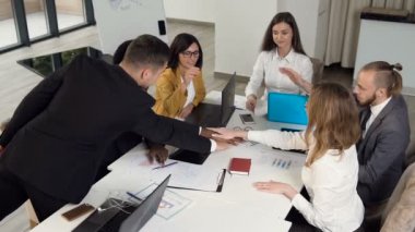 Başarılı iş ekibi beş birbirlerine, ofiste konferans masada oturan veren eşleri ile gösteren birlik çalışıyor. İş yerinde tam konsantrasyon