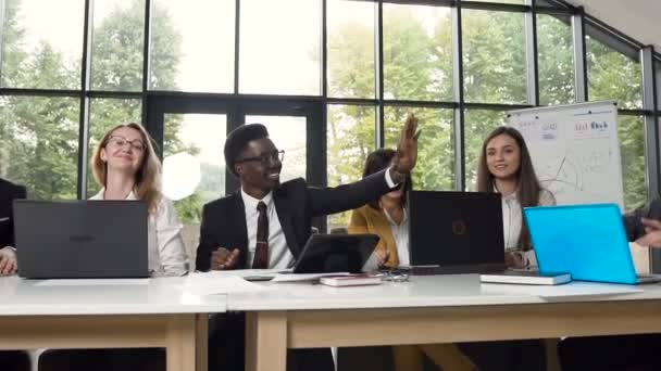 Plusieurs groupes ethniques de jeunes gens d'affaires ont terminé avec succès le projet et se sont donné la main cinq. Concept de travail d'équipe dans un bureau moderne — Video