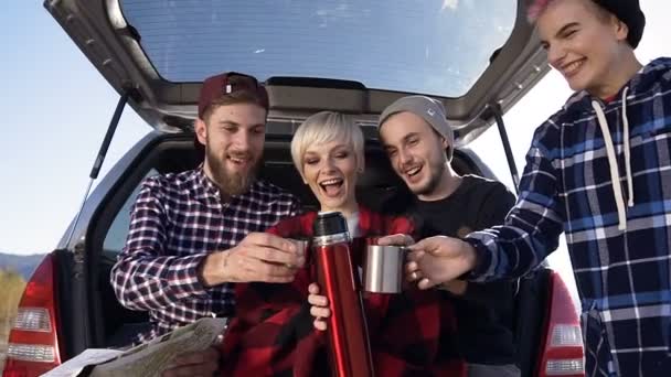 Happy vrienden reizen in de herfst bergen drinken van hete thee leunend op de kofferbak auto suv, praten en lachen. Rijden met de auto in de bergen, de reizen, de toeristen — Stockvideo