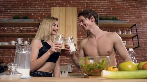 Bonito casal esporte beber leite na cozinha . — Vídeo de Stock