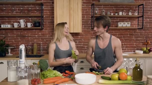 Щаслива спортивна пара готує салат . — стокове відео