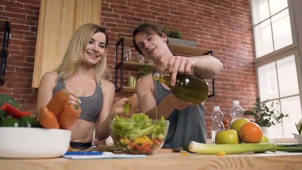 Knappe sport man en vrouw samen koken in de keuken. — Stockvideo