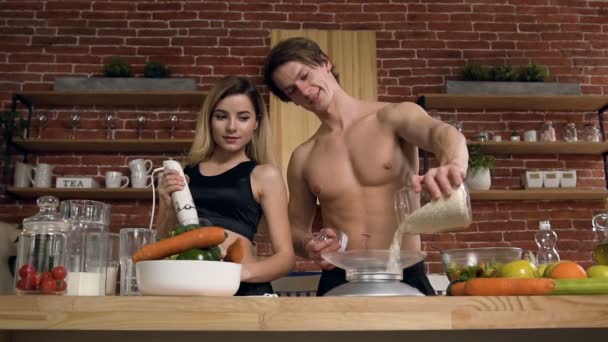 Привлекательная спортивная пара готовит ужин, обед на кухне . — стоковое видео