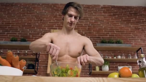 Onderaanzicht van sport man tijdens lunch koken in de keuken. — Stockvideo